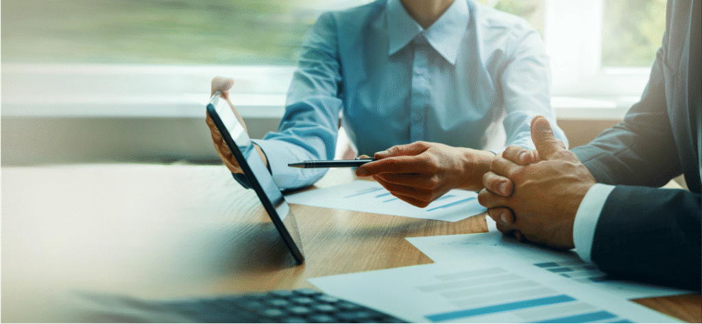 business people looking at costs on tablet - How Business Travel Agents... - Article Article Image - _Expert Advice on Cost Savings and Compliance_