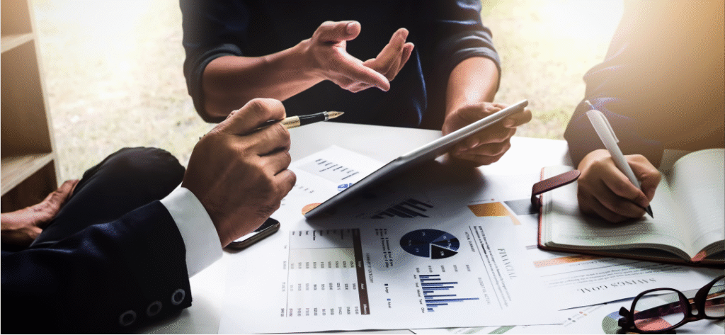 business people looking at spreadsheets -The Hidden Costs... - Article Article Image - _Choosing the Right Business Travel Agency_